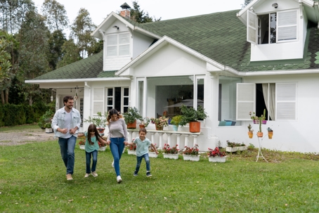 Happy family playing outside their new house.