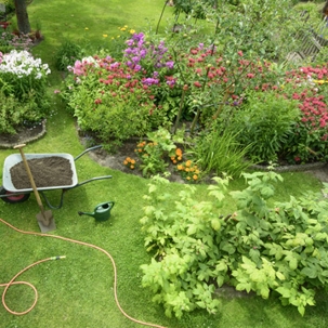 wheelbarrow, shovel, and water hose ready for gardening