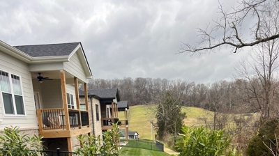 Backyard with artificial turf, shrubs, rocks, and fence. Photo