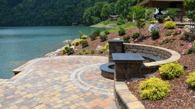 Lakefront patio with fire pit and stone walls. Photo