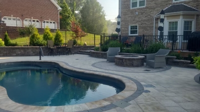 Pool, patio, fire pit, and lounge chairs near houses. Photo