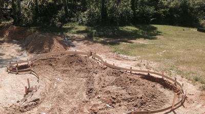 A curved pool is being dug. Photo