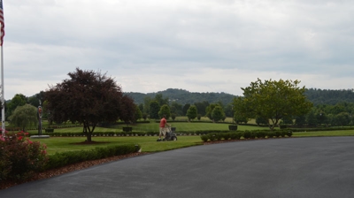 A paved area with trees and a flagpole. Photo