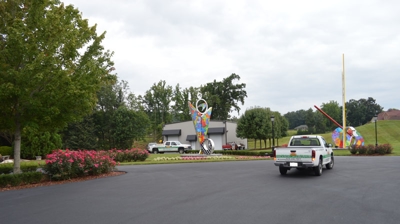 A paved area with landscaping and a vehicle. Photo