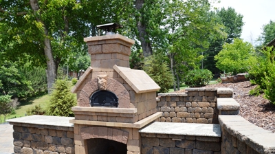 Outdoor stone fireplace with landscaping Photo