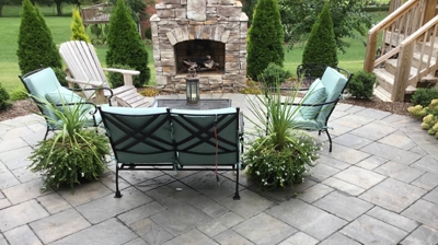 Outdoor patio furniture around a fire pit, gray stone paving Photo