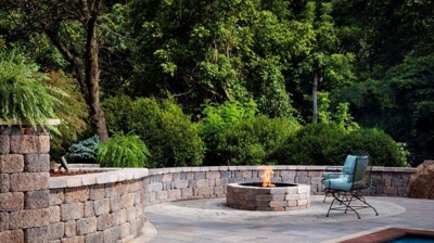 Patio with stone walls, circular fire pit and pool Photo