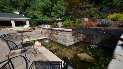 backyard patio with a waterfall in a koi pond. Photo