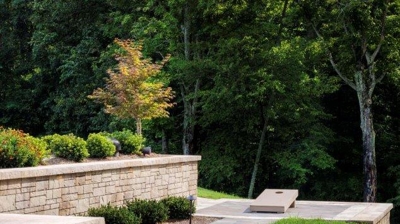 Patio with stone pathways, stone walls and grass Photo