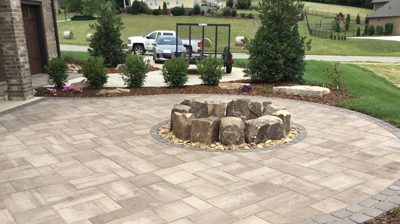 circular stone pit in the middle of a small curved patio area. Photo