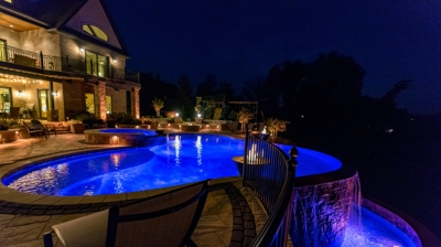 Nighttime view of a lit pool and patio Photo