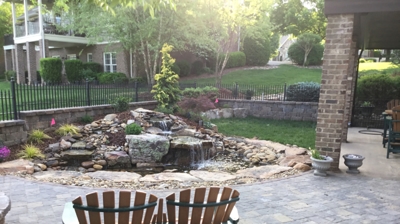 Patio with pond, waterfall, and Adirondack chairs. Photo